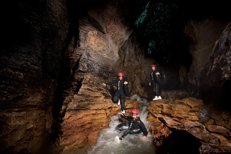 Black water rafters floating through a Waitomo cave on inner tubes