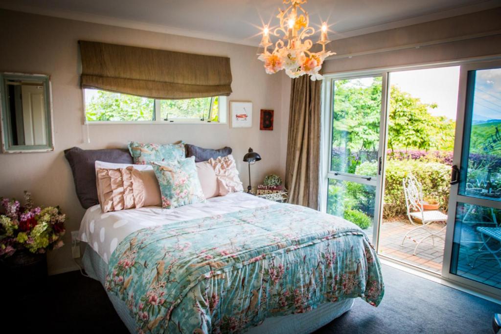 A guest bedroom with a chandelier at Waitomo Orchard Estate B&B